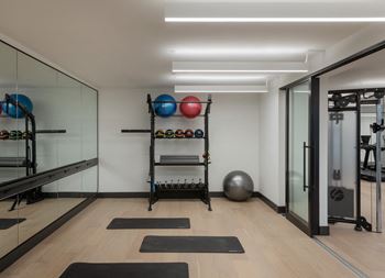 a workout room with mirrors and yoga mats on the floor